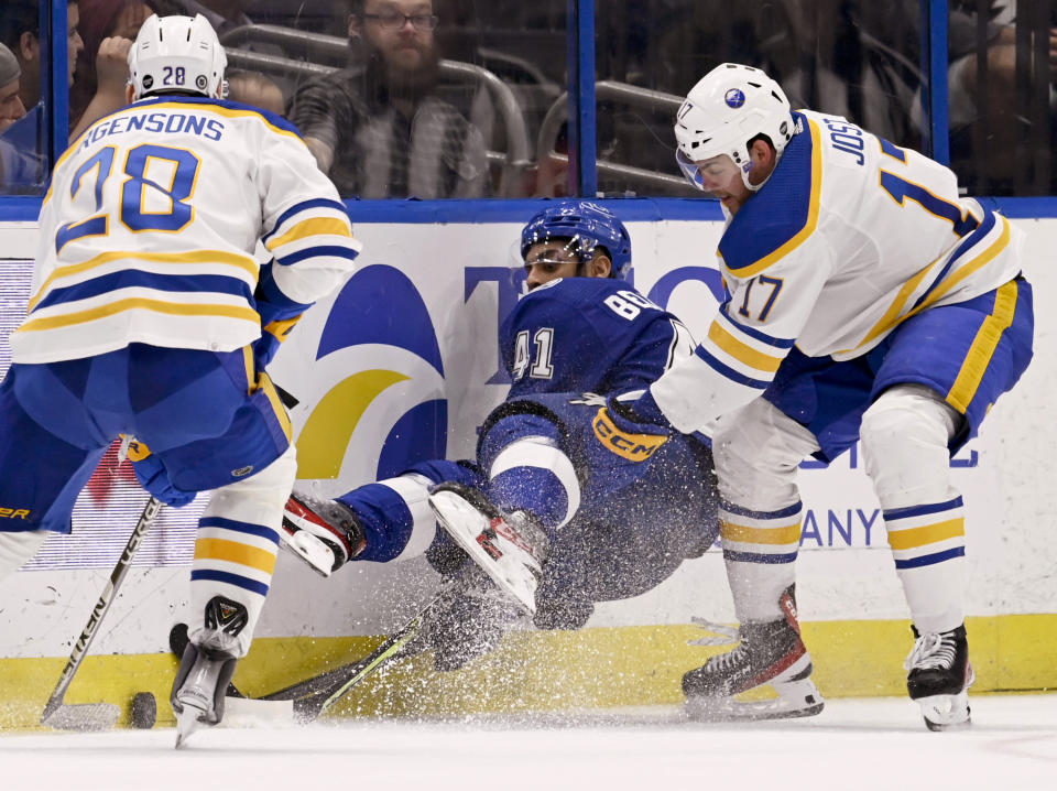 Tampa Bay Lightning left wing Pierre-Edouard Bellemare (41) works for the puck against Buffalo Sabres left wing Zemgus Girgensons (28) and center Tyson Jost (17) during the second period of an NHL hockey game Thursday, Feb. 23, 2023, in Tampa, Fla. (AP Photo/Jason Behnken)
