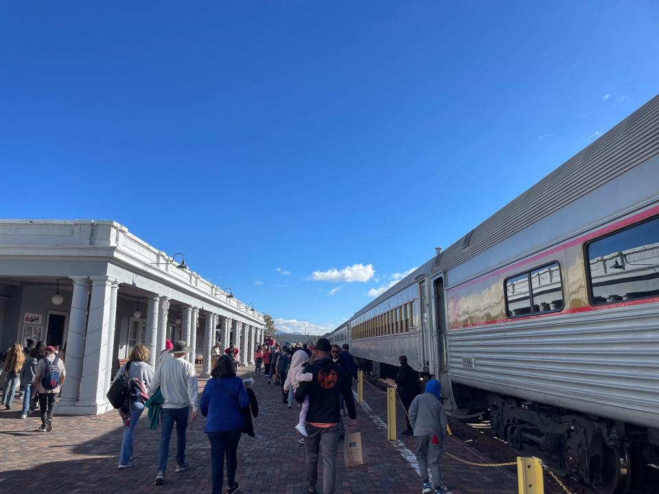 Passengers walk to their train car to board the Grand Canyon Railway train.
