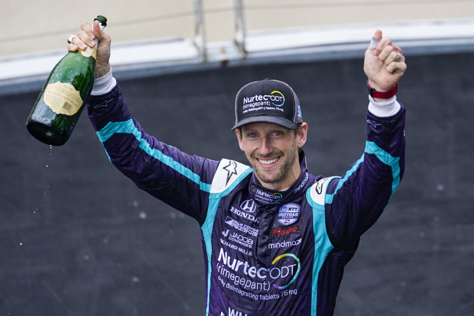 File-This May 15, 2021, file photo shows Romain Grosjean, of Switzerland, celebrating after finishing second in an IndyCar auto race at Indianapolis Motor Speedway in Indianapolis. Grosjean turned in his key to Indianapolis Motor Speedway — yes, he had his own key to the place — packed up his motorhome and headed out Tuesday toward Detroit for his next United States adventure. The man who walked through fire and lived to tell about has fully embraced his move from Formula One to IndyCar, where he won the pole in his third career start then led 44 laps on the road course at Indianapolis before finishing second. (AP Photo/Michael Conroy, File)