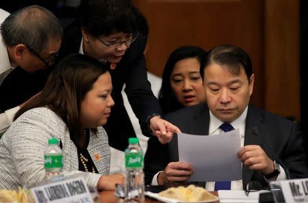 Lorenzo Tan (R), president and chief executive officer of the Rizal Commercial Banking Corp (RCBC) reads a document assisted by his lawyers during a money laundering hearing at Senate in Manila March 15, 2016. REUTERS/Romeo Ranoco