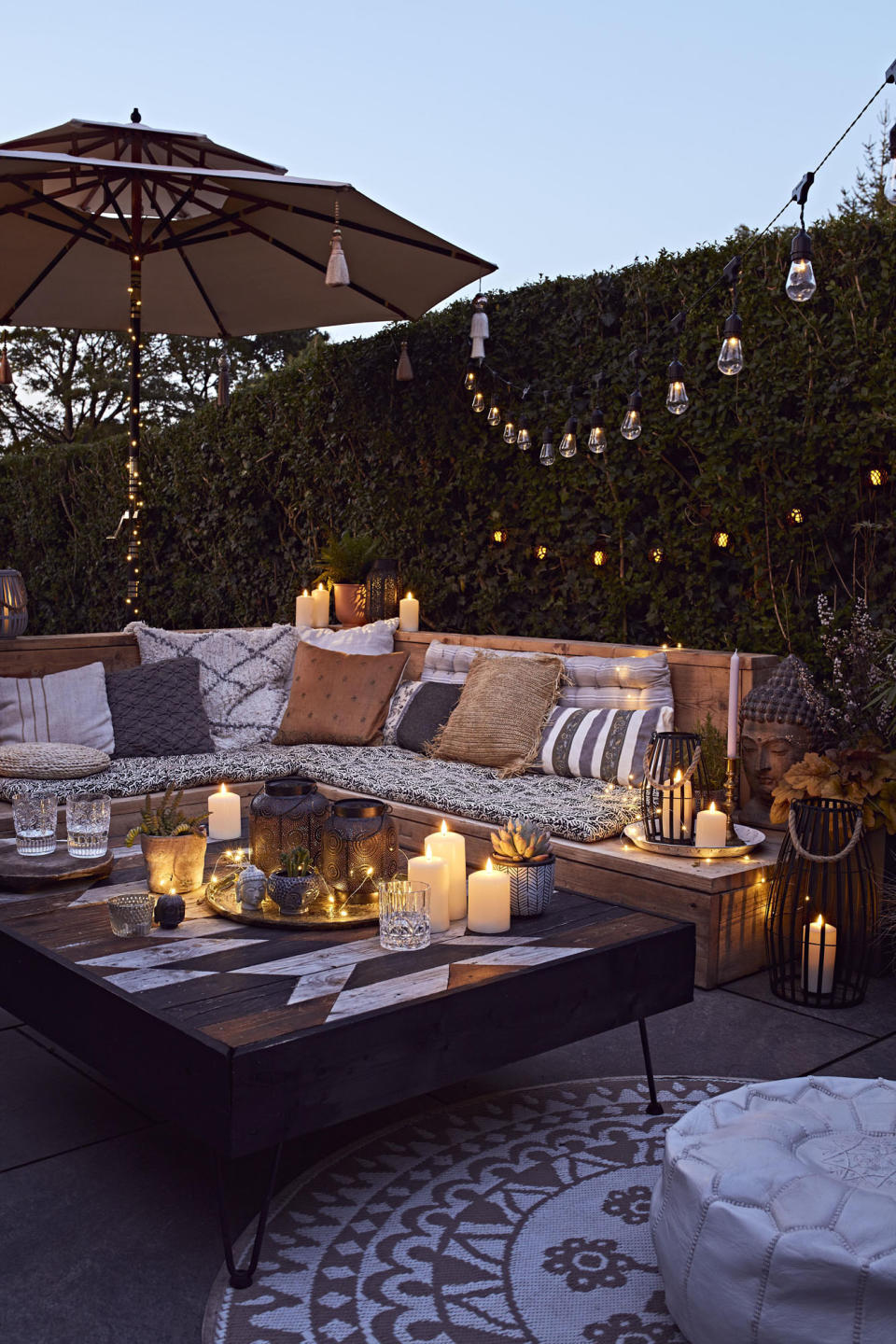 Create inviting corners with garden lighting and comfy cushions