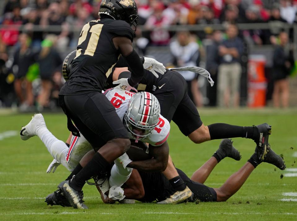 October 14, 2023;  Lafayette, Indiana, USA;  Ohio State Buckeyes running back Chip Trayanum (19) is tackled by Purdue Boilermakers defensive back Sanoussi Kane (21), Purdue Boilermakers defensive back Dillon Thieneman (31) and Purdue Boilermakers defensive back Markevious Brown ( 1), during the first half of Saturday's NCAA split.  Football game at Ross-Ade Stadium in Lafayette.