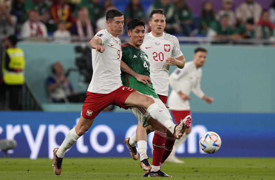 Poland's Robert Lewandowski, Mexico's Edson Alvarez and Poland's Piotr Zielinski, from left, challenge for the ball during the World Cup group C soccer match between Mexico and Poland, at the Stadium 974 in Doha, Qatar, Tuesday, Nov. 22, 2022. (AP Photo/Martin Meissner)