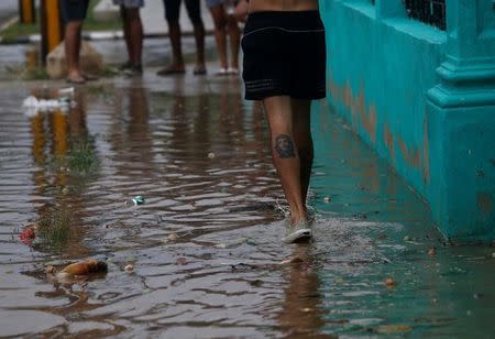 A man walks through a puddle as Hurricane Irma turns toward the Florida Keys on Saturday, in Havana, Cuba September 9, 2017. REUTERS/Stringer