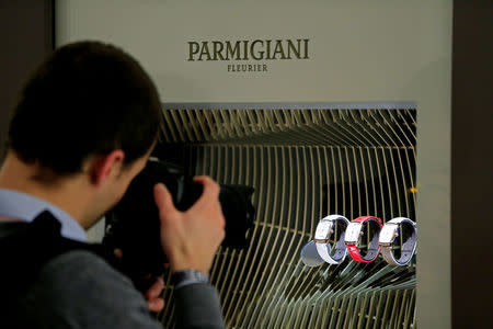 A photographer takes pictures of the Parmigiani stand during the opening day of the Salon International de la Haute Horlogerie (SIHH) fair in Geneva, Switzerland January 16, 2017. REUTERS/Pierre Albouy