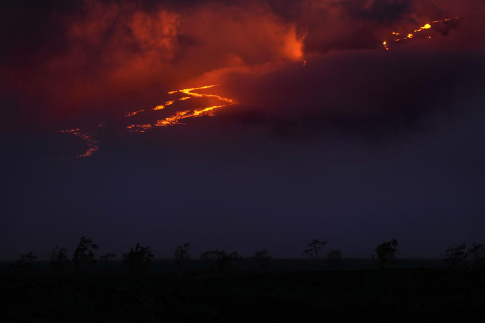 Lava flows through fissures as the Mauna Loa volcano erupts Saturday, Dec. 3, 2022, near Hilo, Hawaii. (AP Photo/Gregory Bull)