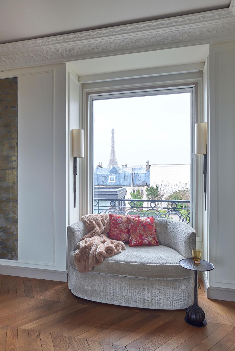 In  an American couple’s Paris pied-à-terre, designed by Benjamin Wood, a window was added to capture the view of the Eiffel Tower from the entrance. The custom window seat is in Sahco fabric and the custom moldings were designed by architect Sandrine Teze-Limal and Staff Espace Volume to hide all of the air-conditioning, heating, and vents throughout the apartment.