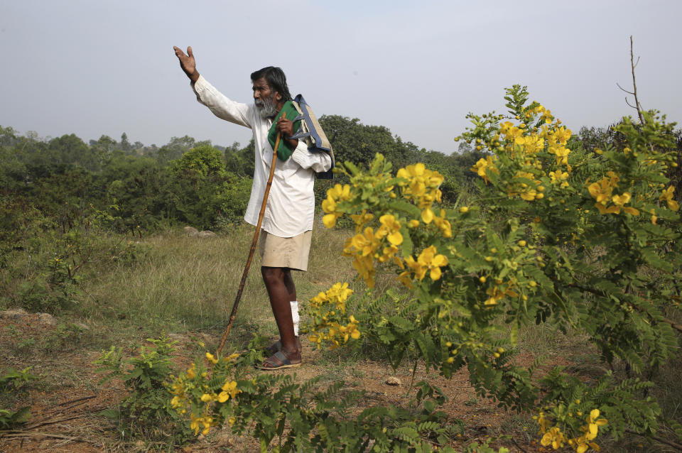 Kalmane Kamegowda, a 72-year-old shepherd, points towards one of the 16 ponds he created at a hillock near Dasanadoddi village, 120 kilometers (75 miles) west of Bengaluru, India, Wednesday, Nov. 25, 2020. Kamegowda, who never attended school, says he's spent at least $14,000 from his and his son’s earnings, mainly through selling sheep he tended over the years, to dig a chain of 16 ponds on a picturesque hill near his village. (AP Photo/Aijaz Rahi)