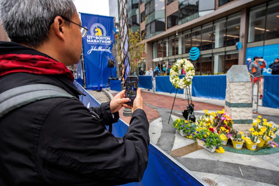 A person takes a photo of a memorial for those killed in the bombing at the Boston Marathon ten years ago in Boston, Massachusetts, on April 16, 2023, the day before this year's race.