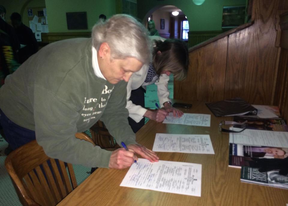 Marsha Caspar, 51, left, and Glenna DeJong, 53, of Lansing sign documents on Saturday, March 22, before they were married at the Ingham County Courthouse in the central Michigan city of Mason by County Clerk Barb Byrum. The wedding came the day after the state's ban on gay marriage was scratched from the state constitution by a federal judge. (AP Photo/Emma Fidel)