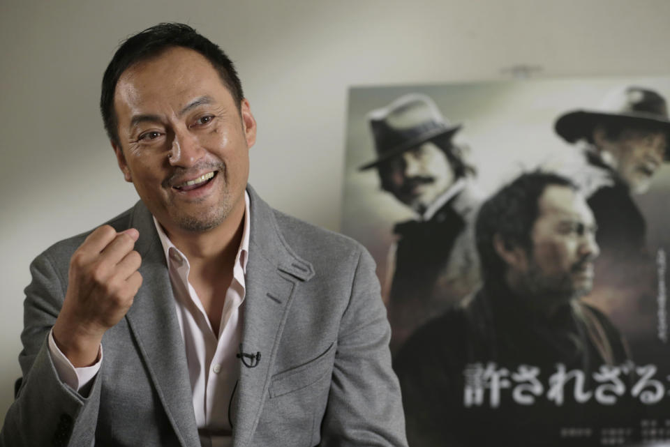 In this Tuesday, Sept. 3, 2013 photo, Japanese actor Ken Watanabe speaks during an interview in Tokyo. The Japanese remake of Clint Eastwood’s “Unforgiven” isn’t a mere cross-cultural adaptation but more a tribute to the universal spirit of great filmmaking for its star Watanabe. “I was convinced from the start that this will be an original Japanese movie in its own right,” said Watanabe, who has become the go-to Japanese actor for Hollywood. Watanabe was happy Eastwood welcomed the idea of the remake, and they kept in touch. But, once the shooting began, he was focused on delivering what director Lee Sang-il wanted in the new movie, not an easy re-interpretation. Japanese characters written on the poster reads: "Unforgiven." (AP Photo/Shizuo Kambayashi)