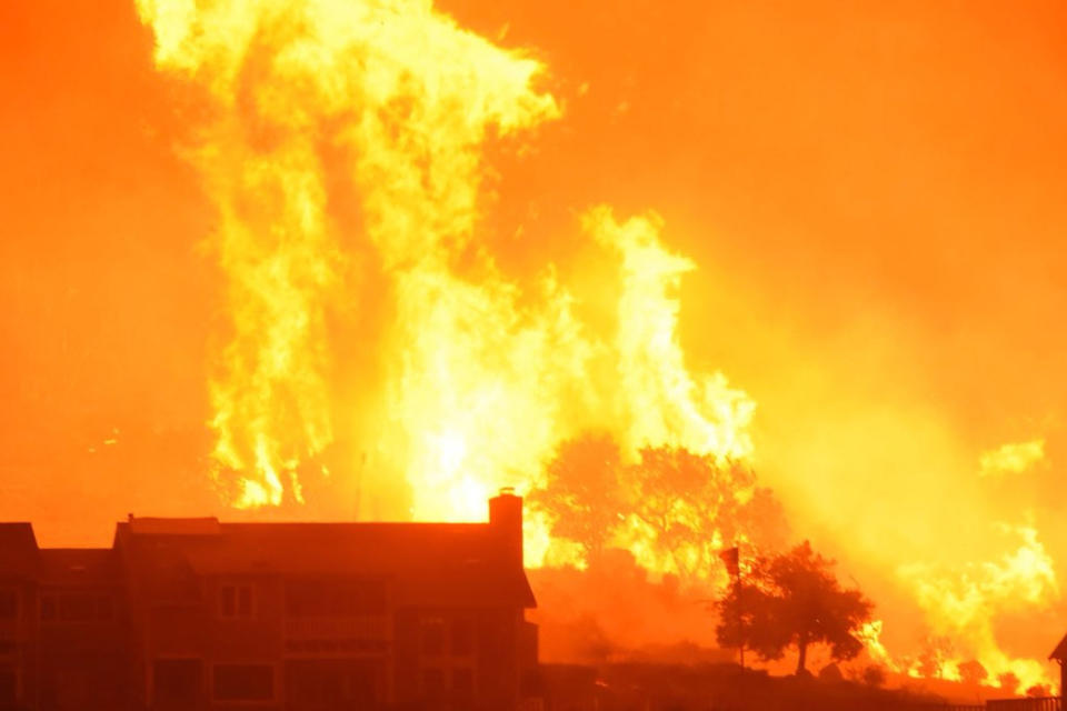 <p>Flames advance on homes in Carpinteria, which is just south of Santa Barbara, California, on December 10.</p>