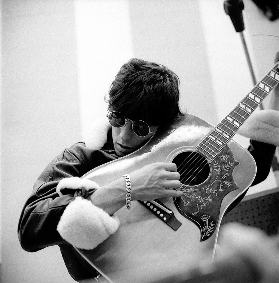 Keith Richards tuning his guitar at the end of a tour in 1965 (Gered Mankowitz / Iconic Images)