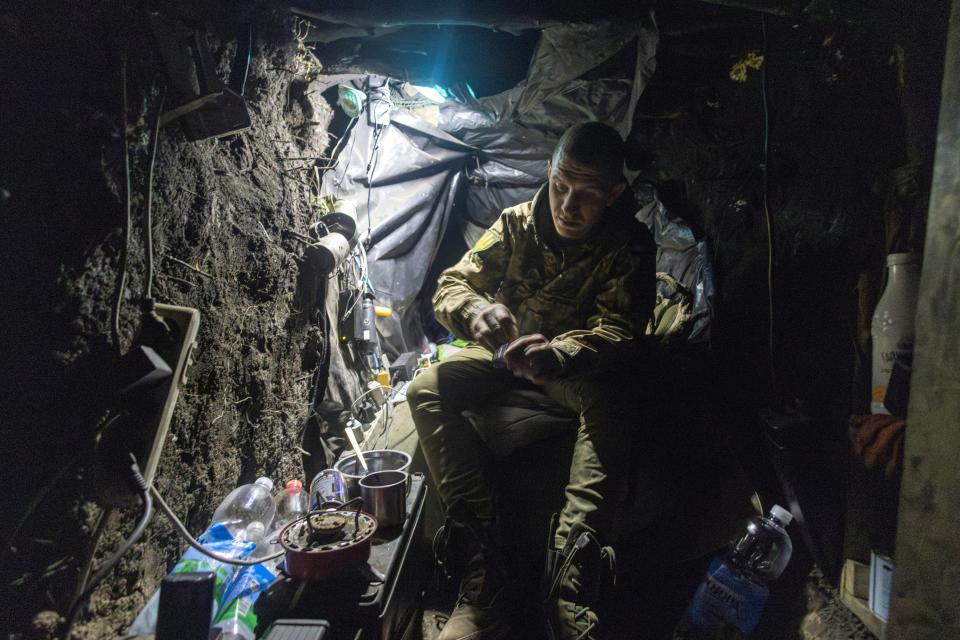 A infantry soldier of Ukraine's 58th Motorized Brigade sits in the dugout where he sleeps in a frontline trench in the Donetsk region (REUTERS)