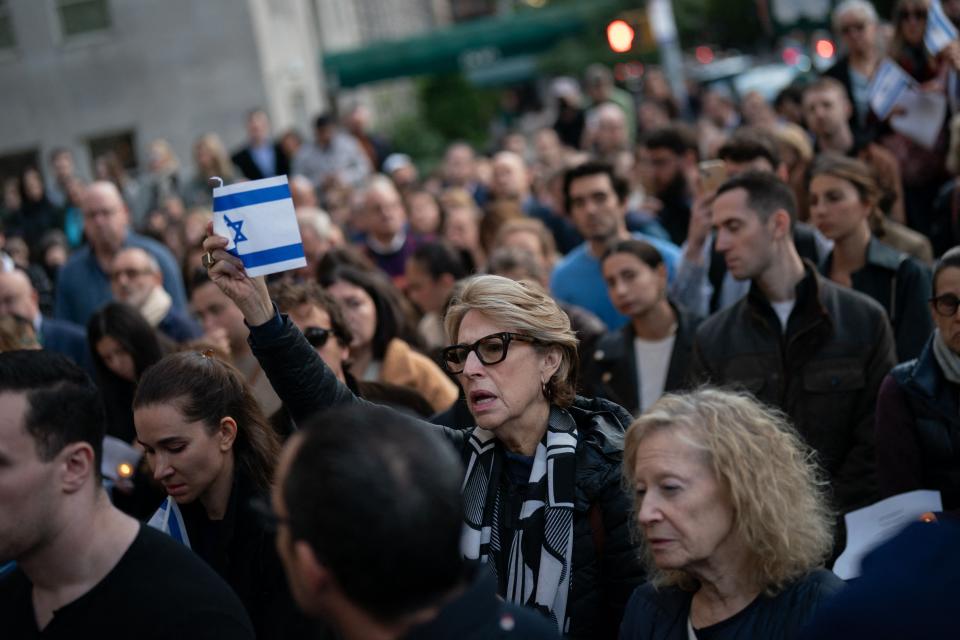 A person holds an Israeli flag as people attend a prayer service and candlelight vigil for Israel at Temple Emanu-El in New York City on October 9, 2023, after the Palestinian militant group Hamas launched an attack on Israel.   