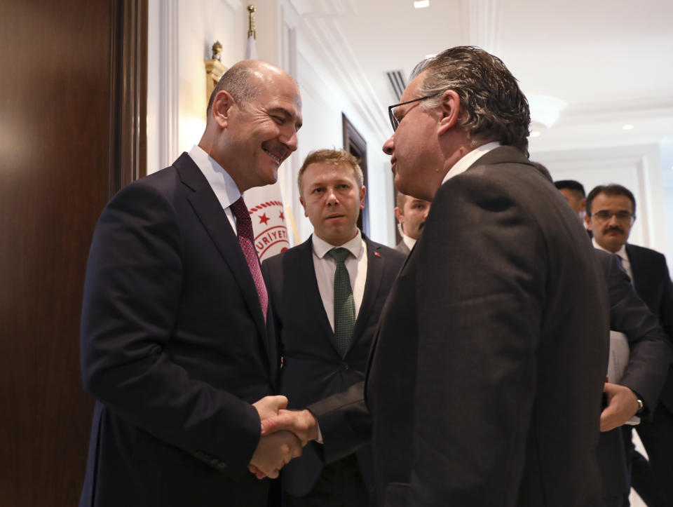 Turkey's Interior Minister Suleyman Soylu, left, shakes hands with George Koumoutsakos, right, Greece's Alternate Minister for immigration policy in the Ministry of Citizen's Protection of Greece, prior to their meeting in Ankara, Turkey, Thursday, Oct. 3, 2019. Soylu is scheduled to have a meeting later on Thursday with his French and German counterparts on the EU-Turkey migration agreement and supporting EU-member Greece in coping with migrant arrivals. (AP Photo/Ali Unal)