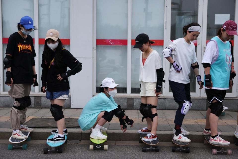 Members of Beijing Girls Surfskating Community stand on skateboards as they attend a training session for beginners (Reuters)