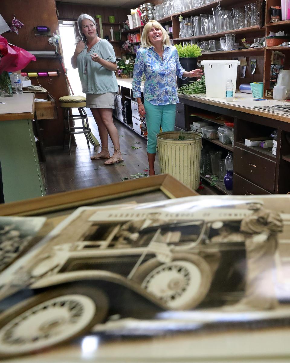 Caines Flowers co-owners Ariel Fuller, left, and Bunde Roebuck fondly discuss old memories of the Barberton shop’s 1931 Chevrolet Woody.