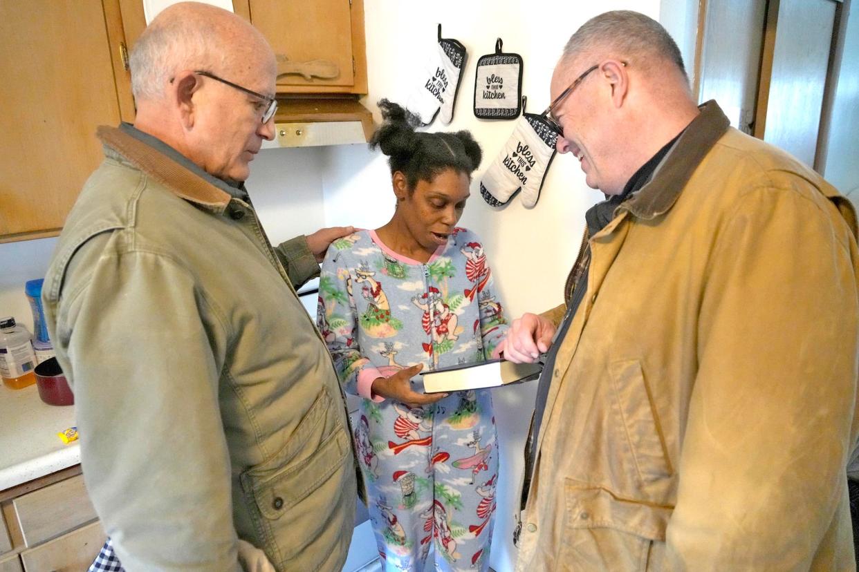Jessica McThune (center) is handed a bible as volunteers Brian Gesch (left) and Rep. Terry Katsma talk with her after she received donated mattresses and other furniture at her residence the northwest side of in Milwaukee on Friday, Jan. 5, 2024. For over 30 years, Lloyd’s Trailer Ministry has been making deliveries of donated furniture from Sheboygan County to Milwaukee 2-3 times a week.