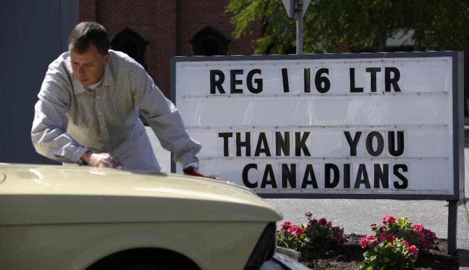 In this Thursday, May 23, 2013 photo, Canadian Christian Skuggedal cleans off his car after filling the gas tank in Blaine, Wash. In April 2013, in its 2014 fiscal year budget proposal, the Department of Homeland Security requested permission to study a fee at the nation's land border crossings. The request has sparked wide opposition among members of Congress from northern states, who vowed to stop it. A fee, they say, would hurt communities on the border that rely on people, goods and money moving between the U.S. and Canada. (AP Photo/Elaine Thompson)