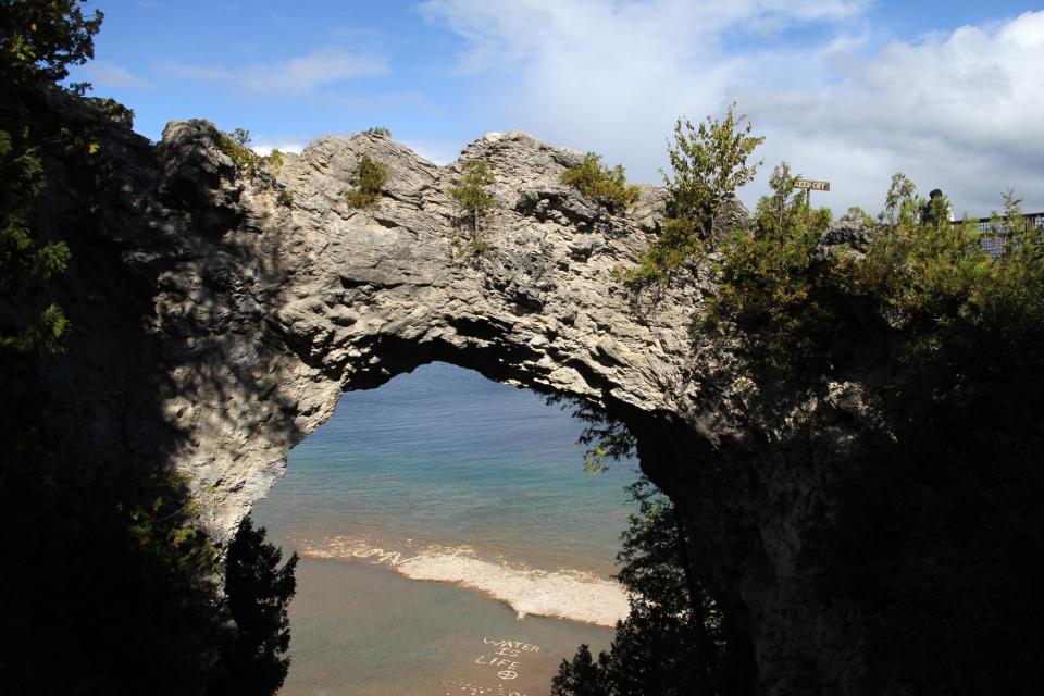 This Sept. 23, 2012 photo shows Lake Huron as seen through Arch Rock, a natural stone formation on Mackinac Island, Mich., on Lake Huron. The island offers Victorian charm in modern times, with a century-long ban on motor vehicles, but visitors can hike or bike to Arch Rock and other attractions. (AP Photo/Anick Jesdanun)