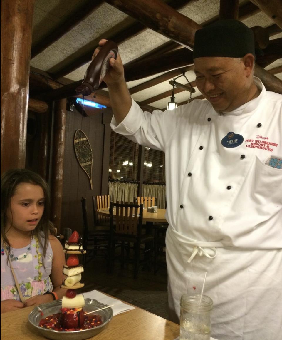 A chef pours chocolate syrup on a dairy-free dessert.