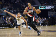 Golden State Warriors guard Stephen Curry, left, chases Portland Trail Blazers guard CJ McCollum (3) in the first half of a preseason NBA basketball game in San Francisco, Friday, Oct. 15, 2021. (AP Photo/John Hefti)