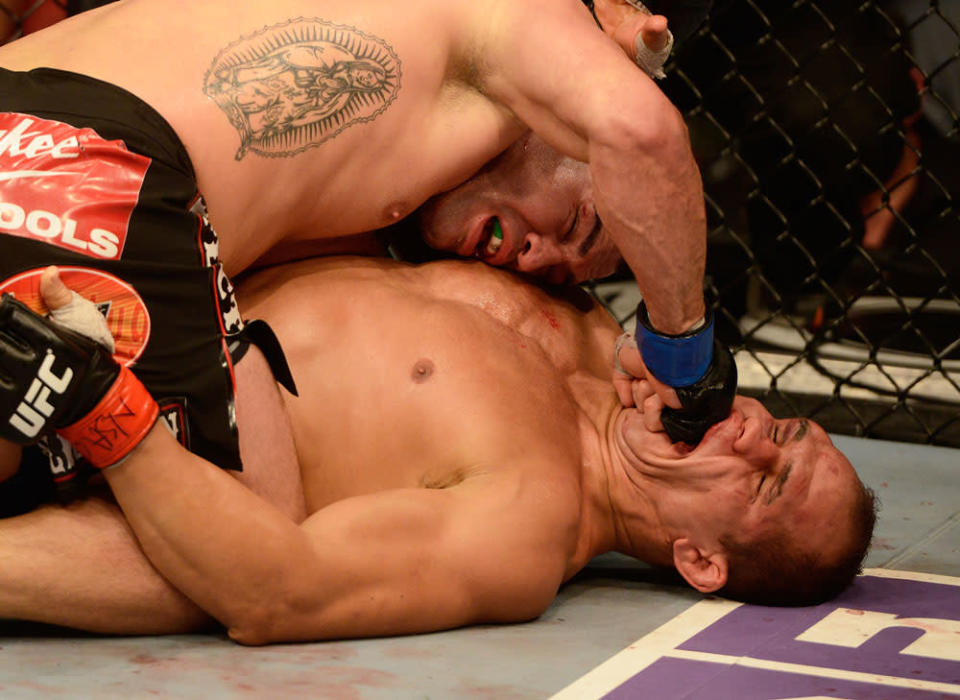 Junior dos Santos eats a punch from Cain Velasquez during their fight at UFC 155. (Getty)