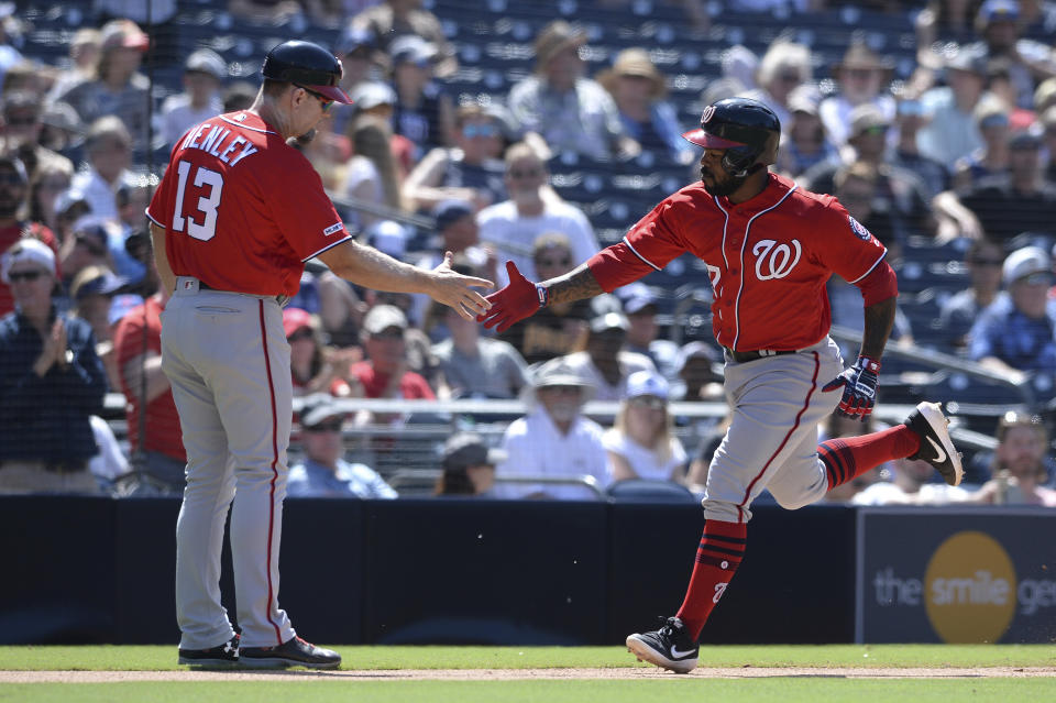 Washington Nationals' Howie Kendrick, right, is congratulated by third base coach Bob Henley after hitting a home run during the eighth inning of a baseball game against the San Diego Padres, Sunday, June 9, 2019, in San Diego. (AP Photo/Orlando Ramirez)