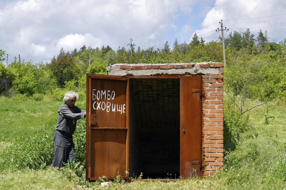 A local resident Nikolai Kononenko, 67, opens the door of a bomb shelter in the village of Mayaky, Donetsk region, Ukraine, Friday, May 27, 2022. (AP Photo/Andriy Andriyenko)