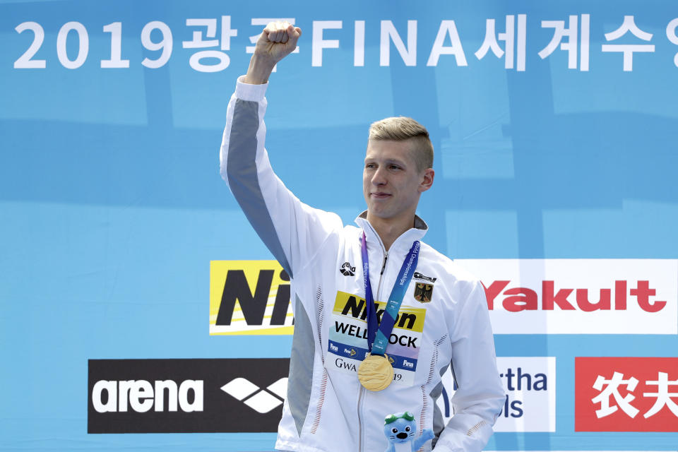 Gold medalist Florian Wellbrock of Germany stands with his medal after the men's 10km open water swim at the World Swimming Championships in Yeosu, South Korea, Tuesday, July 16, 2019. (AP Photo/Mark Schiefelbein)