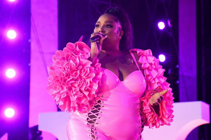 Lizzo performs onstage in a pink bodysuit