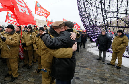 Men embrace as veterans of the military campaign attend a ceremony marking the 30th anniversary of the withdrawal of Soviet troops from Afghanistan at Victory Park, also known as Poklonnaya Gora War Memorial Park, in Moscow, Russia February 15, 2019. REUTERS/Shamil Zhumatov