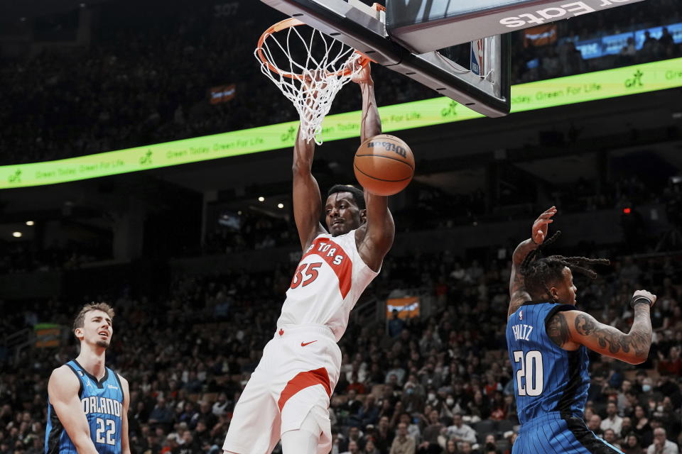 Toronto Raptors' Christian Koloko dunks on Orlando Magic's Franz Wagner (22) and Markelle Fultz during the first half of an NBA basketball game, Saturday, Dec. 3, 2022 in Toronto. (Chris Young/The Canadian Press via AP)