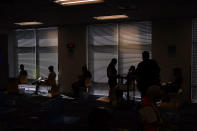 Amazon employees wait after getting coronavirus vaccinations at a vaccination event for workers at an Amazon Fulfillment Center, Wednesday, March 31, 2021, in North Las Vegas, Nev. A growing number of companies and labor unions are directly securing coronavirus vaccines for their workers. Amazon and some other large companies have hosted on-site inoculations, while smaller operations have helped book appointments for their workers. (AP Photo/John Locher)