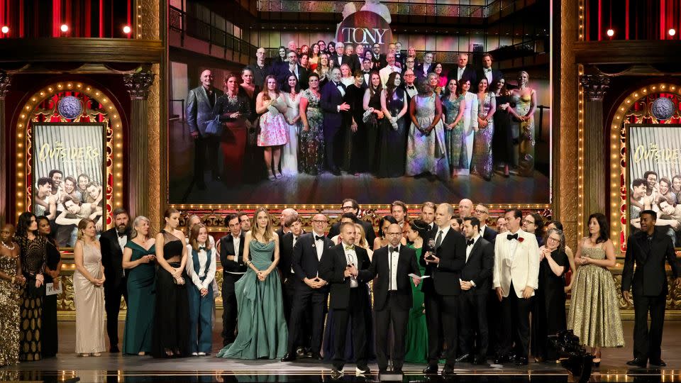 Vivienne Jolie, Angelina Jolie, Sky Lakota-Lynch, Adam Rapp, Matthew Rego, Danya Taymor, Hank Unger, and cast and crew accept the best musical award for "The Outsiders." - Theo Wargo/Getty Images for Tony Awards Productions