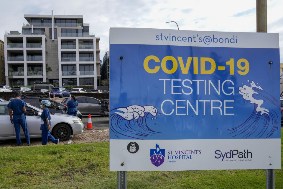 Staff check a client at a drive-through COVID-19 testing clinic at Bondi Beach in Sydney, Australia, Saturday, Jan. 8, 2022. Australia's most populous state has reinstated some restrictions and suspended elective surgeries as COVID-19 cases surged to another record. (AP Photo/Mark Baker)