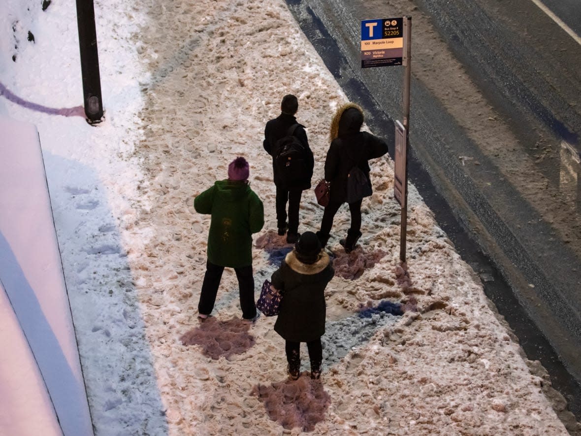 People wait for a bus during the morning commute in Vancouver on Jan. 16, 2020. According to TransLink, overnight snowfall caused road chaos resulting in delays for bus riders in Metro Vancouver on Wednesday morning. (Ben Nelms/CBC - image credit)