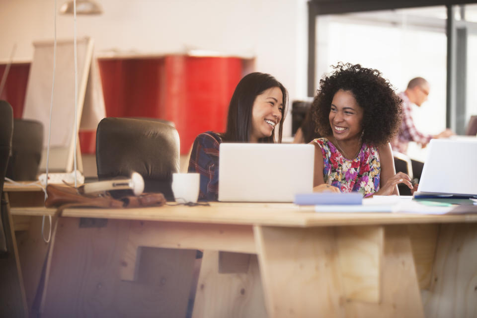 Women laughing at work. (Getty Images)