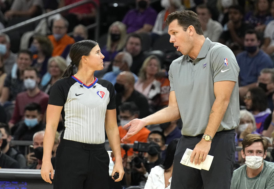 Sacramento Kings head coach Luke Walton talks to NBA official Natalie Sago during the first half of an NBA basketball game against the Phoenix Suns, Wednesday, Oct. 27, 2021, in Phoenix. (AP Photo/Rick Scuteri)