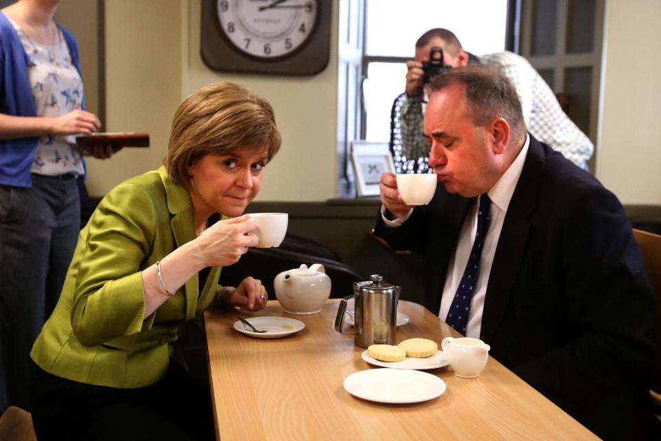 A file picture of Nicola Sturgeon enjoying a cup of tea with Alex Salmond while on the General Election campaign trail (PA)