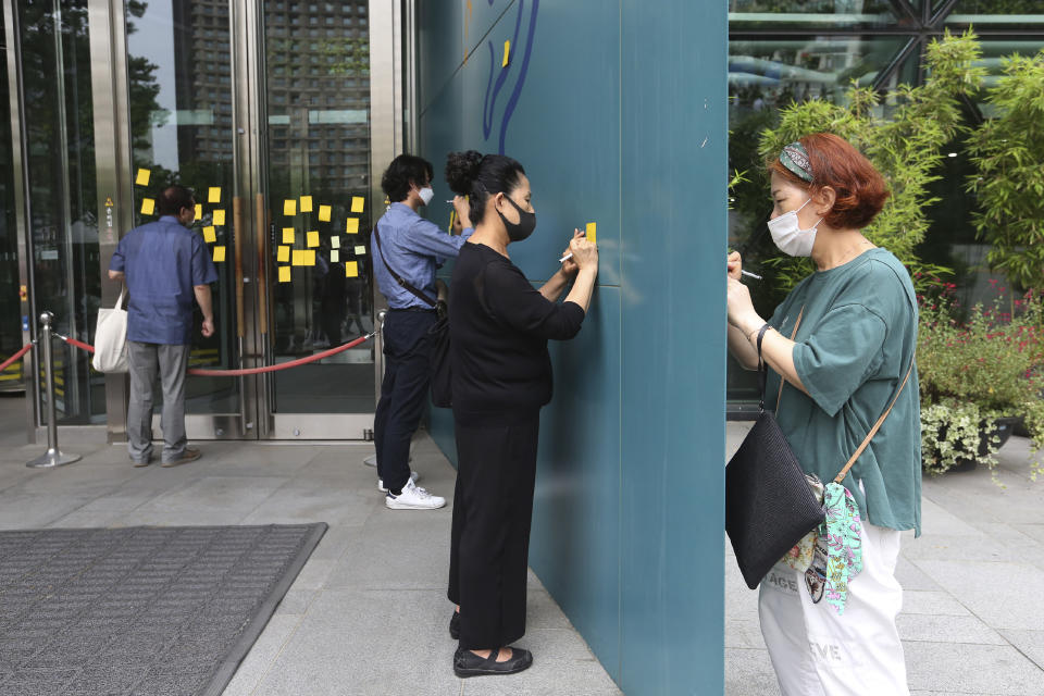 Mourners write condolence messages on paper notes for late Seoul Mayor Park Won-soon in front of City Hall in Seoul, South Korea, Sunday, July 12, 2020. The sudden death of Seoul's mayor, reportedly implicated in a sexual harassment complaint, has prompted an outpouring of public sympathy even as it has raised questions about a man who built his career as a reform-minded politician and self-described feminist. (AP Photo/Ahn Young-joon)