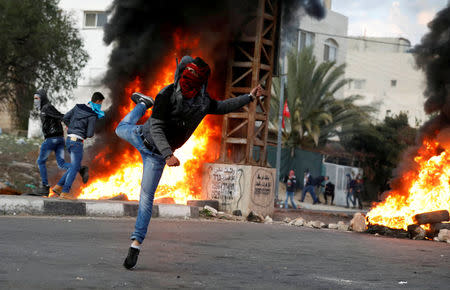 A Palestinian demonstrator hurls stones toward Israeli troops during clashes at a protest against U.S. President Donald Trump's decision to recognize Jerusalem as the capital of Israel, near the West Bank city of Nablus, December 29, 2017. REUTERS/Mohamad Torokman TPX IMAGES OF THE DAY