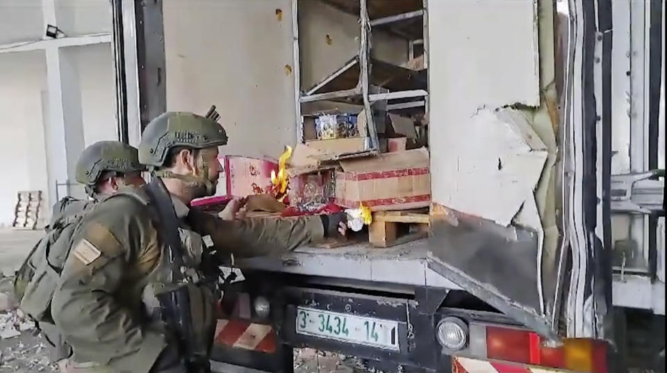 This image made from an undated video shared on X, formerly known as Twitter, shows Israel Army troops trying to burn food and water supplies in the back of an abandoned truck in Gaza. Several viral videos of Israeli soldiers behaving inappropriately in Gaza have emerged in recent days, creating a headache for the Israeli military as it faces an international outcry over its tactics and the rising civilian death toll in its war against Hamas. (X via AP)