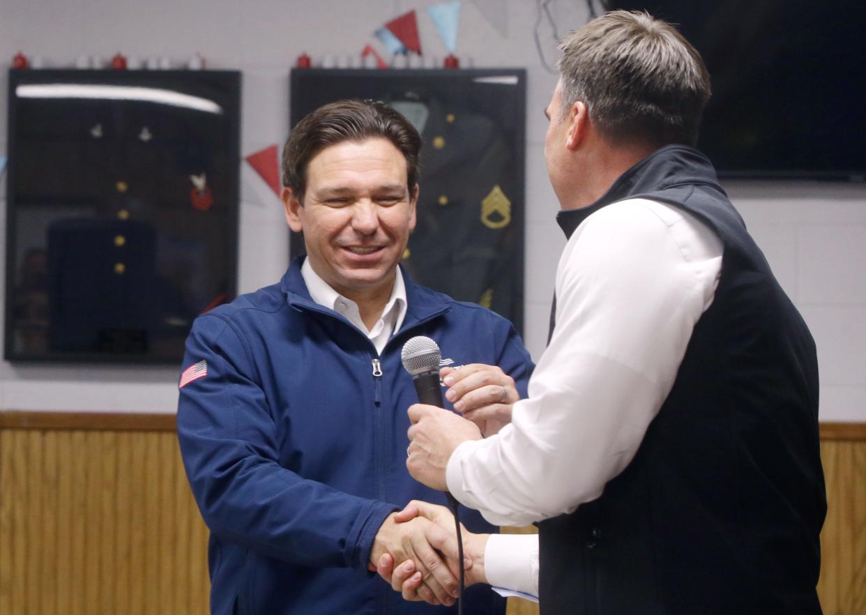 Ron DeSantis shakes Oklahoma Gov. Kevin Stitt's hand as he's introduced Thursday, Dec. 21, 2023 at American Legion Post 721 in Coralville, Iowa.