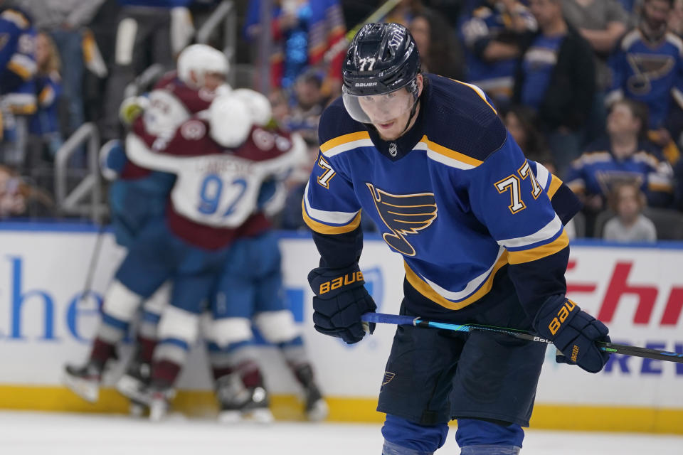 St. Louis Blues' Niko Mikkola, right, reacts as teammates congratulate Colorado Avalanche's Darren Helm on his game-winning goal in the background during the third period in Game 6 of an NHL hockey Stanley Cup second-round playoff series Friday, May 27, 2022, in St. Louis. Colorado won the game to win the series 4-2. (AP Photo/Jeff Roberson)