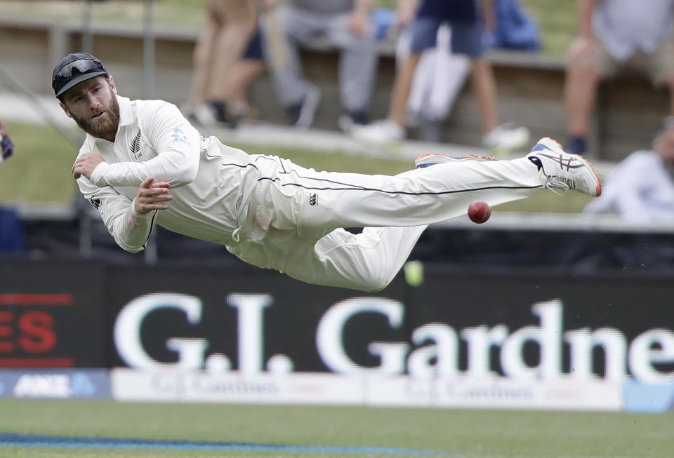 New Zealand's Kane Williamson is airborne as he throws the ball at the stumps during play on day three of the second cricket test between England and New Zealand at Seddon Park in Hamilton, New Zealand, Sunday, Dec. 1, 2019. (AP Photo/Mark Baker)