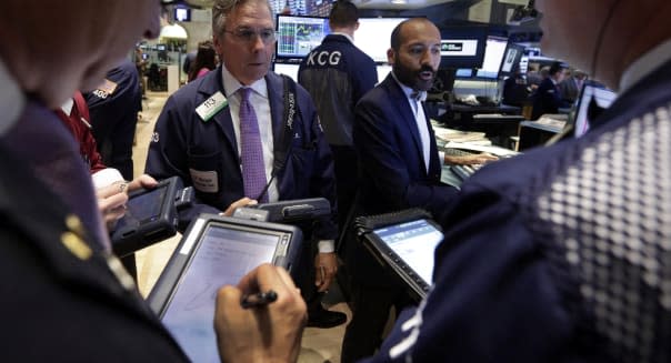 Specialist Fabian Caceres, background right, works with traders on the floor of the New York Stock Exchange Wednesday, July 31, 2013. Steady growth in the U.S. economy and higher company earnings are pushing the stock market higher in early trading. (AP Photo/Richard Drew)