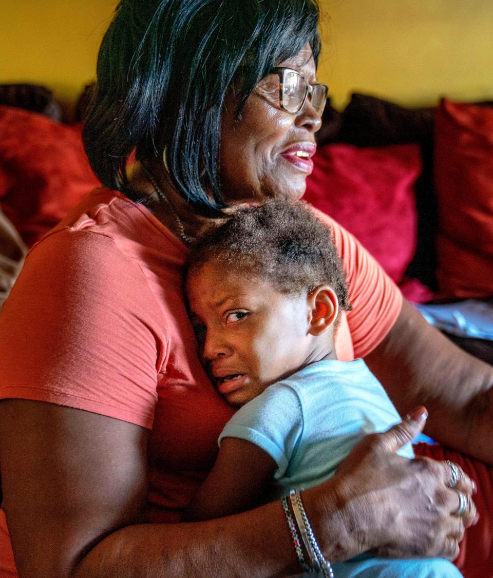 Catherine Hall comforts her grandaughter Hor’Hyrum. The child's mother is in the hospital unable to communicate, but when Catherine brought the baby to visit she could fee her daughter's body heave, as if trying to speak.