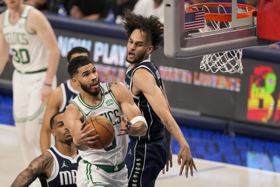 Boston Celtics forward Jayson Tatum, center, goes up for a basket against Dallas Mavericks center Dereck Lively II, right, during the first half in Game 3 of the NBA basketball finals, Wednesday, June 12, 2024, in Dallas. (AP Photo/Sam Hodde)